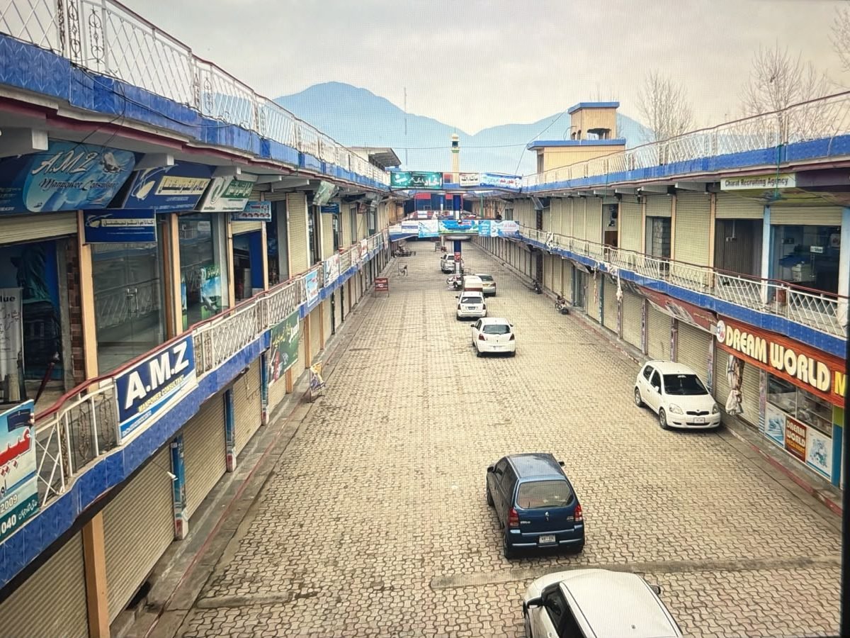 Gul City Center by G & S Builders — two floors of shops facing each other across a paved street, walkways along the upper floor and a mosque at the far end