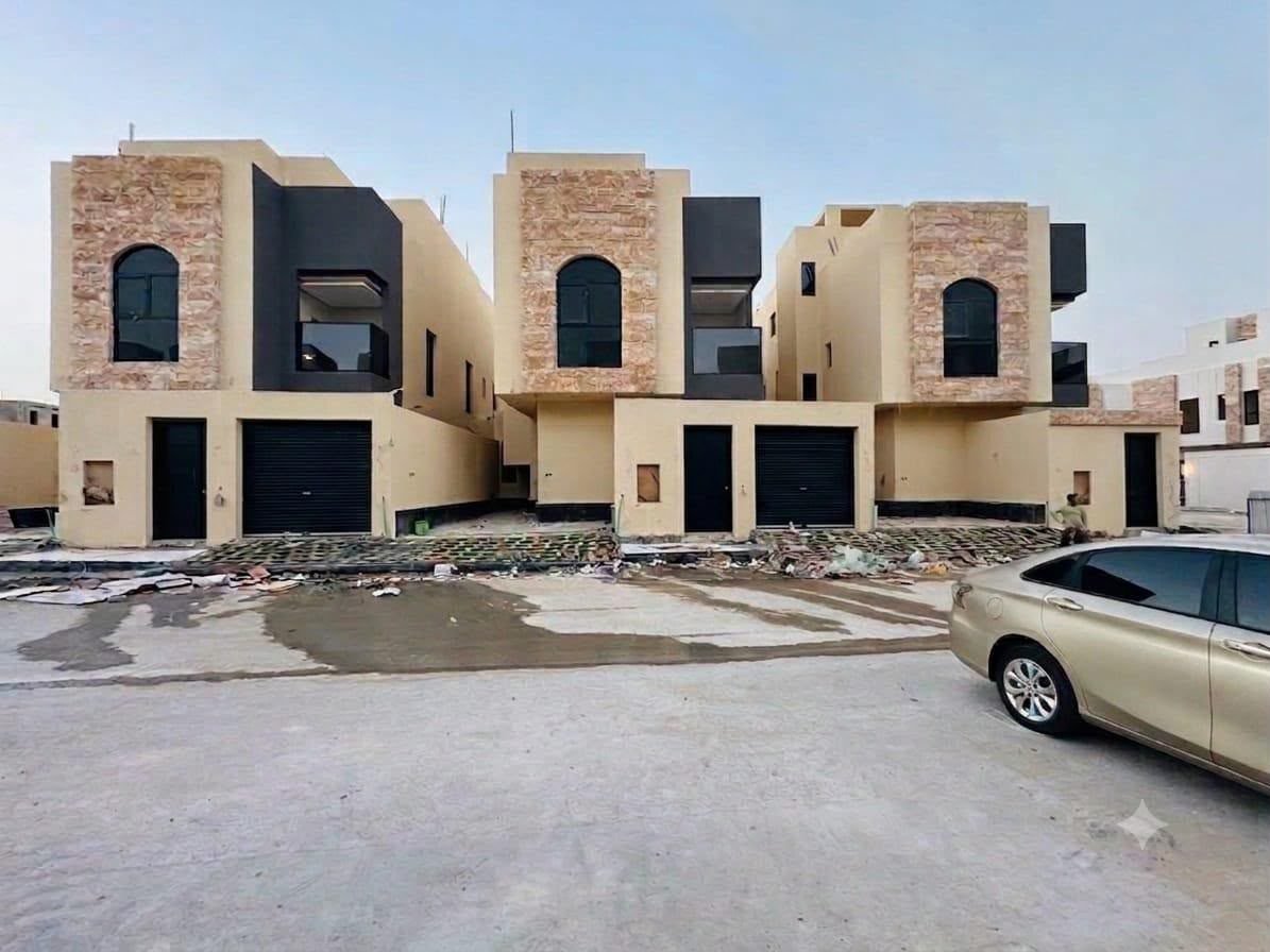 A row of family villas built by G & S Builders in Riyadh, Saudi Arabia — cut-stone towers with arched windows, dark glazed boxes and garages at street level
